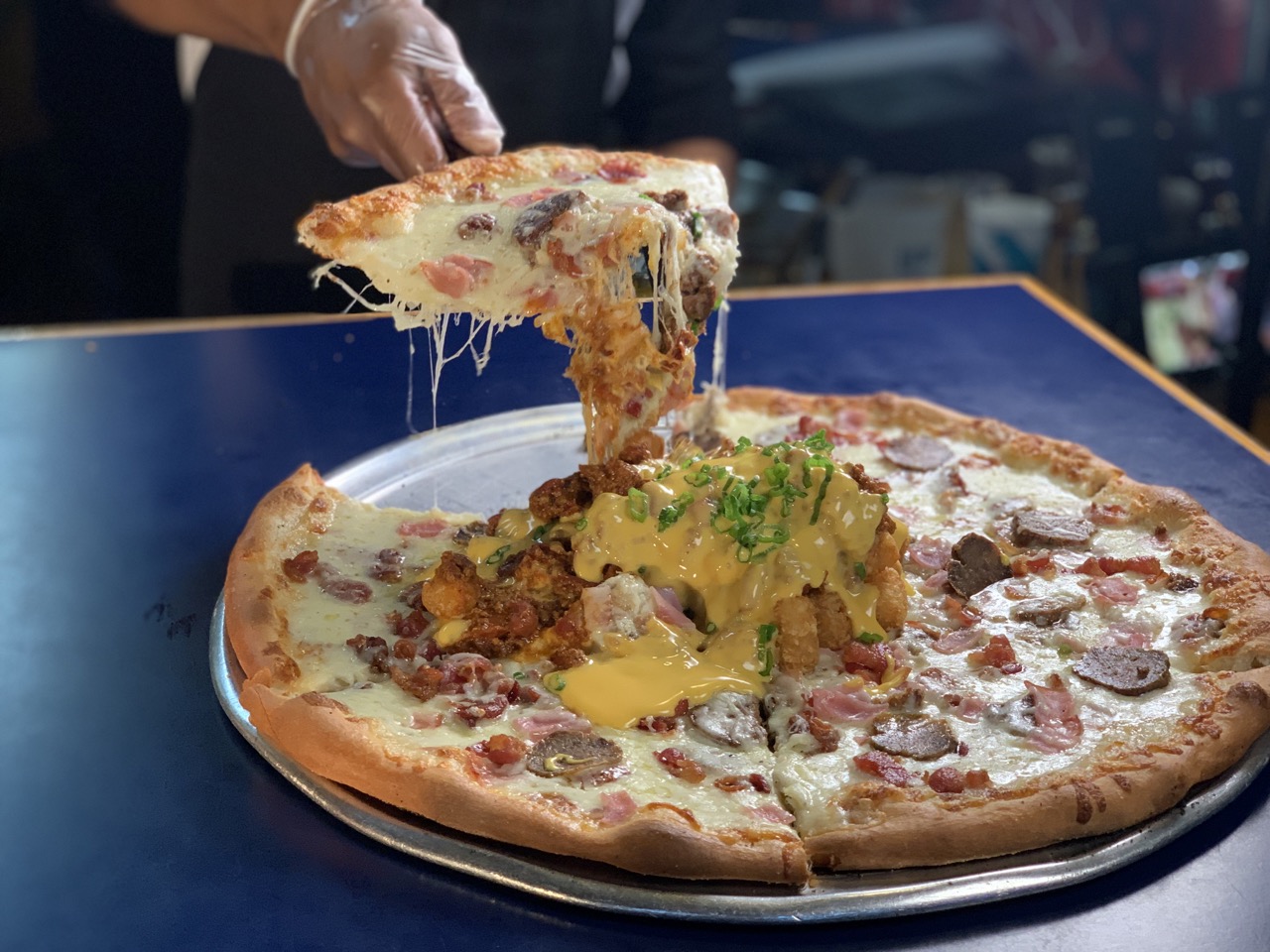 Grinder pizza pie with a bomb on top. A bomb is tots, chili, cheeze whiz, and chives