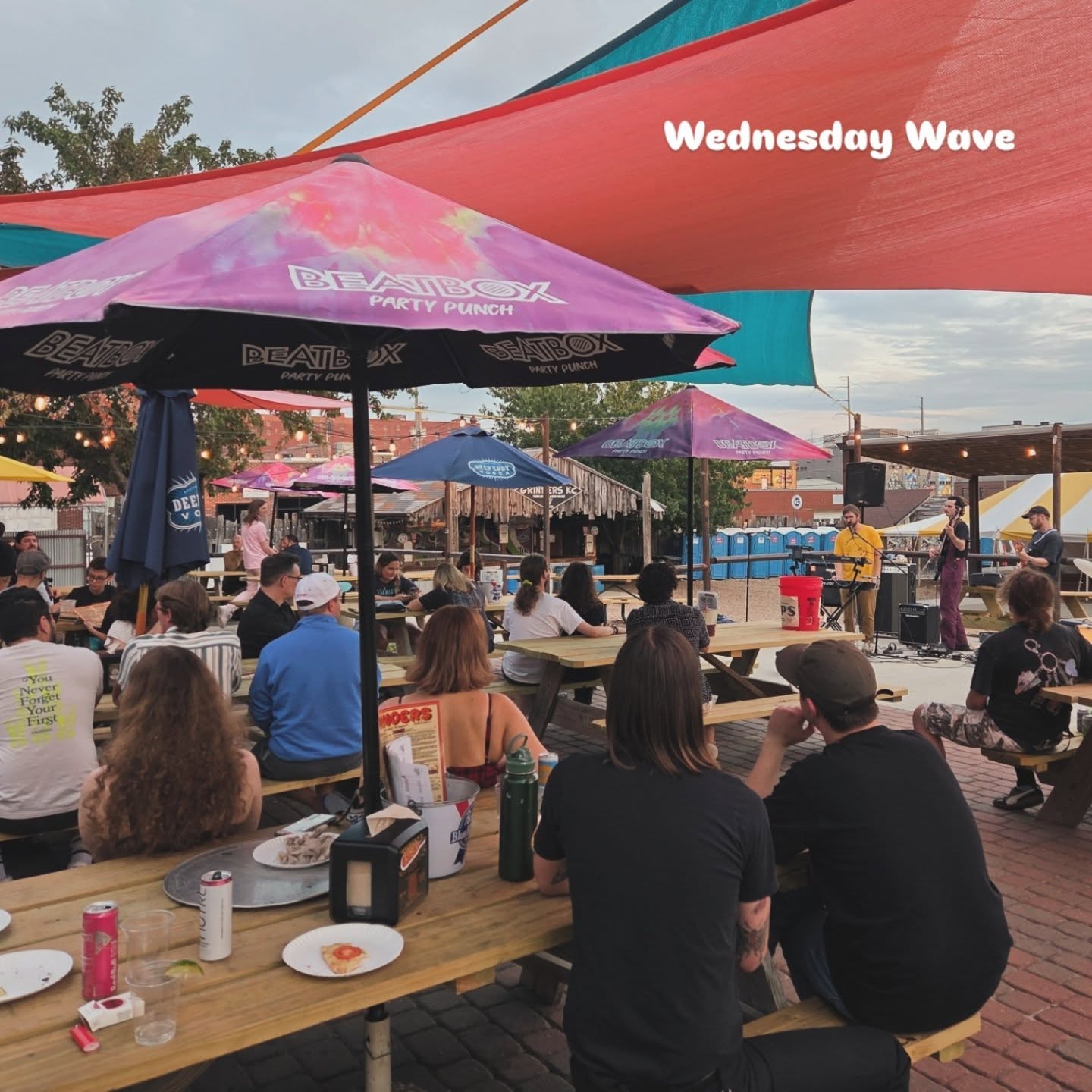 View of a Wednesday Wave Performance from behind patio tables